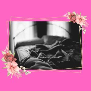 black and white bed with sheets surrounded by flowers